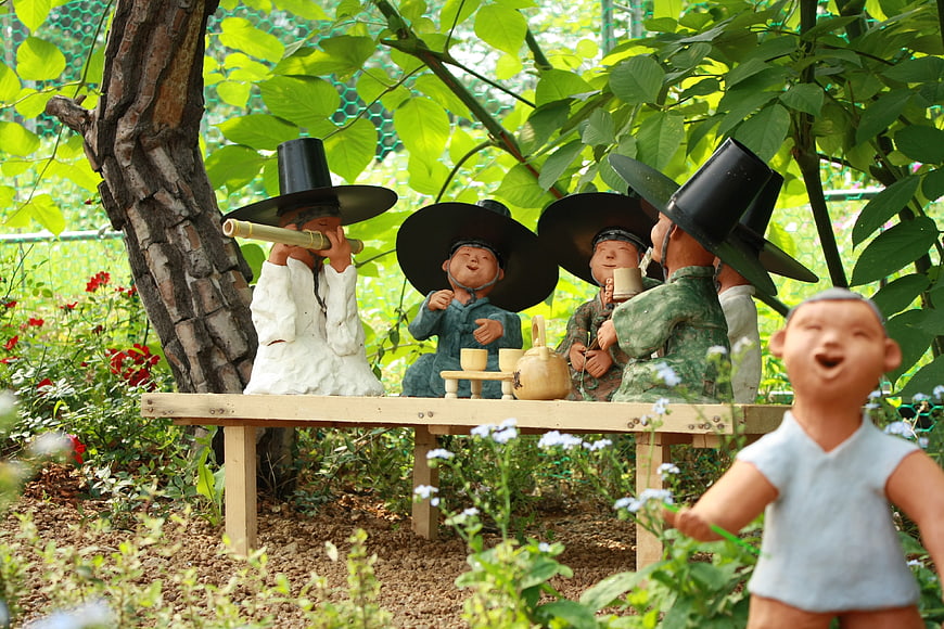 Traditional Korean Clay Figurines in Garden Setting