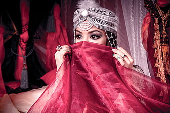 Young woman in ornate silver headdress and red veil