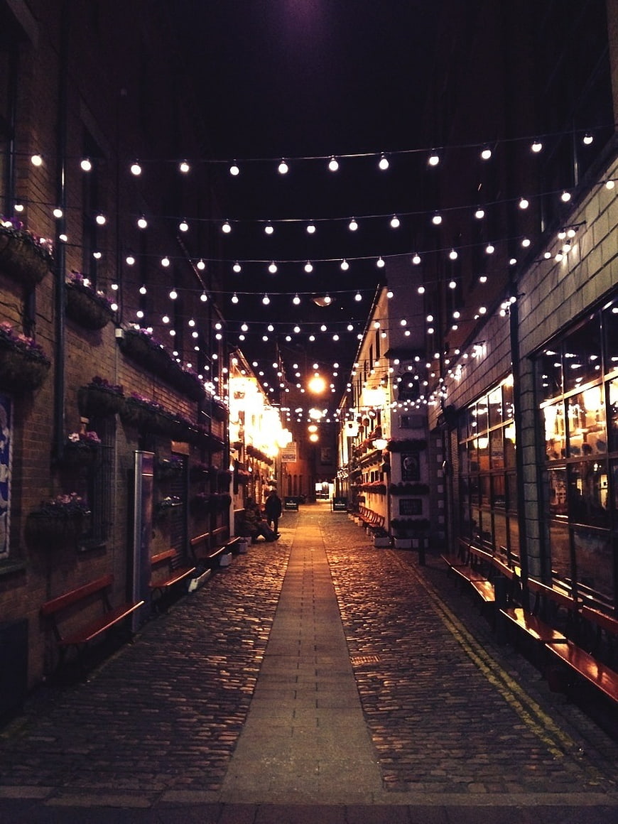 Cobblestone Street with Festive String Lights at Night