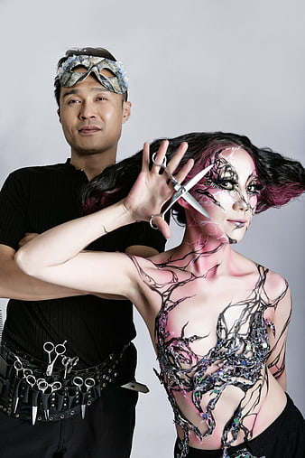 Creative hairdresser and model with avant-garde body art makeup