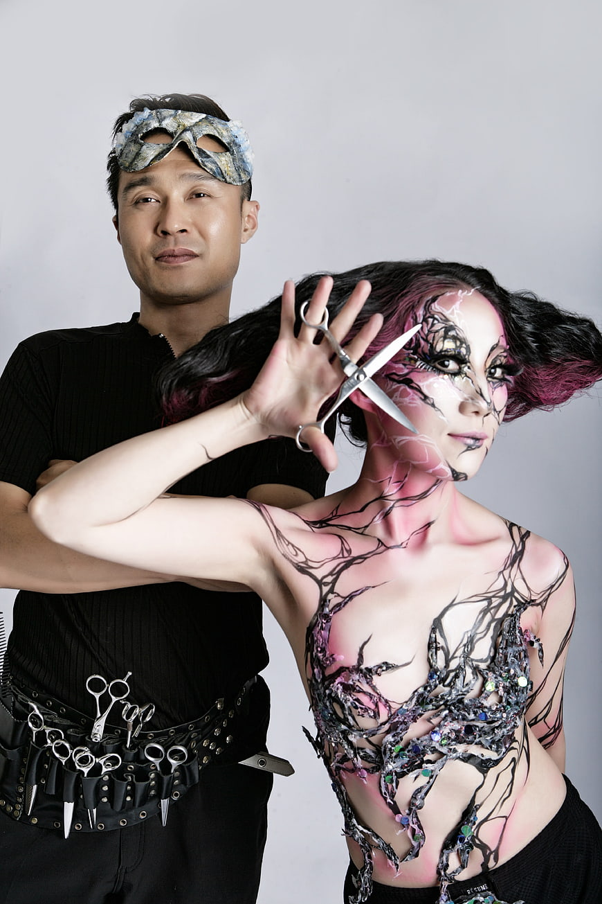 Creative hairdresser and model with avant-garde body art makeup