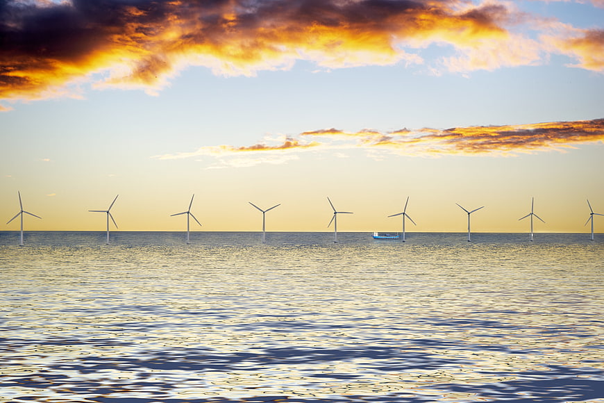 Offshore Wind Turbines In Sea At Golden Hour
