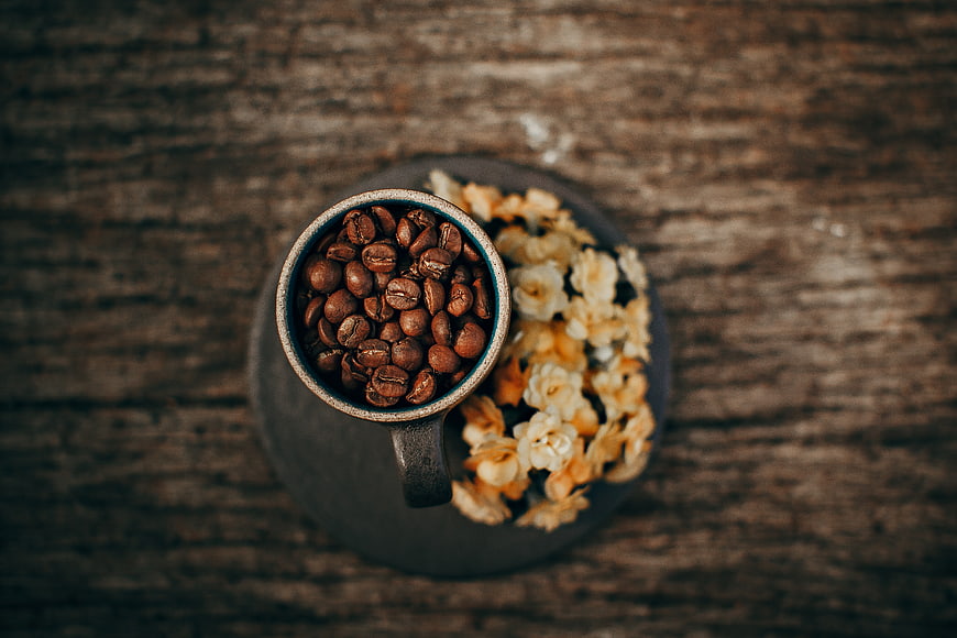 Top View of Coffee Beans in Ceramic Cup with Dried Flowers