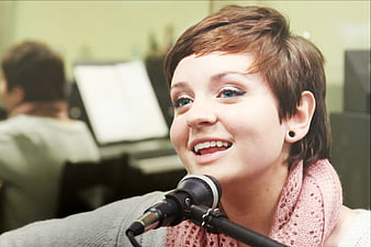 Young Woman Singing into Microphone in Studio