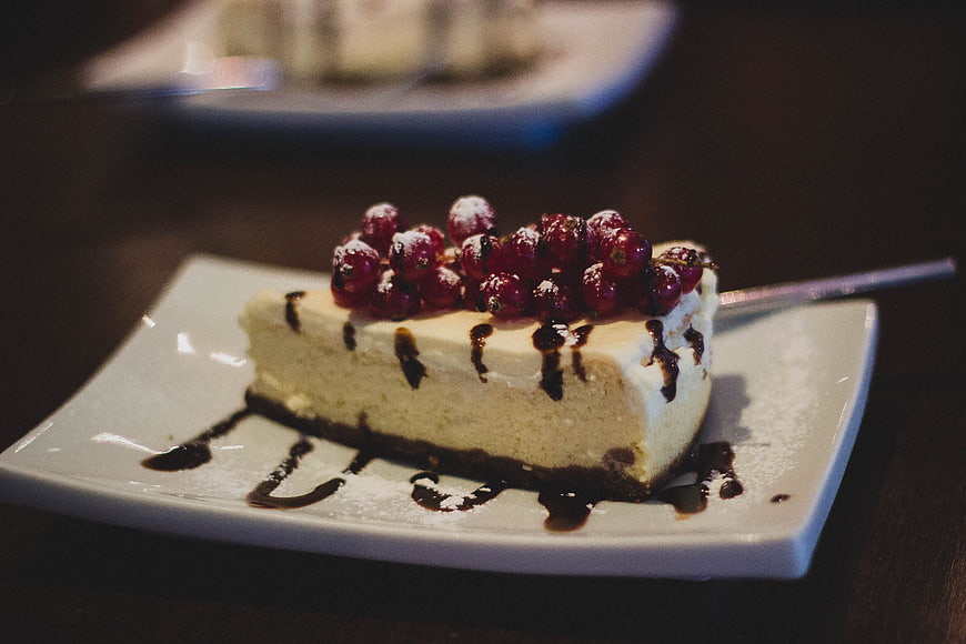 Cheesecake Slice with Red Currants and Chocolate Drizzle