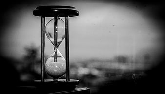 Black and white hourglass with sand running out