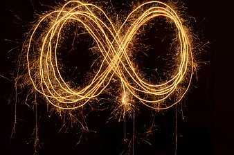 Golden Infinity Symbol Created With Sparkler Light Painting On Black Background