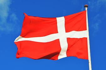 Danish Flag Waving Against Blue Sky