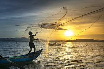 Fisherman Casting Net at Sunset on Ocean