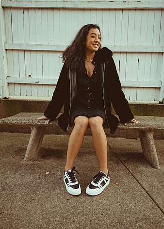 Young Asian Woman Sitting on Concrete Bench Smiling