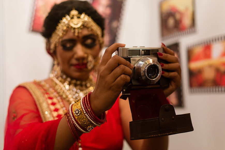 Indian Bride in Red Saree Holding Vintage Camera