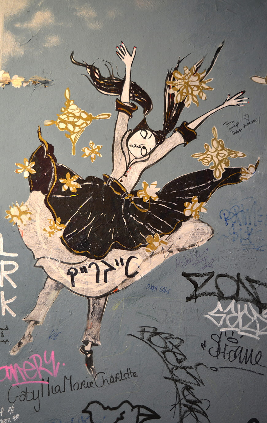 Street art mural of a dancing girl with gold flowers