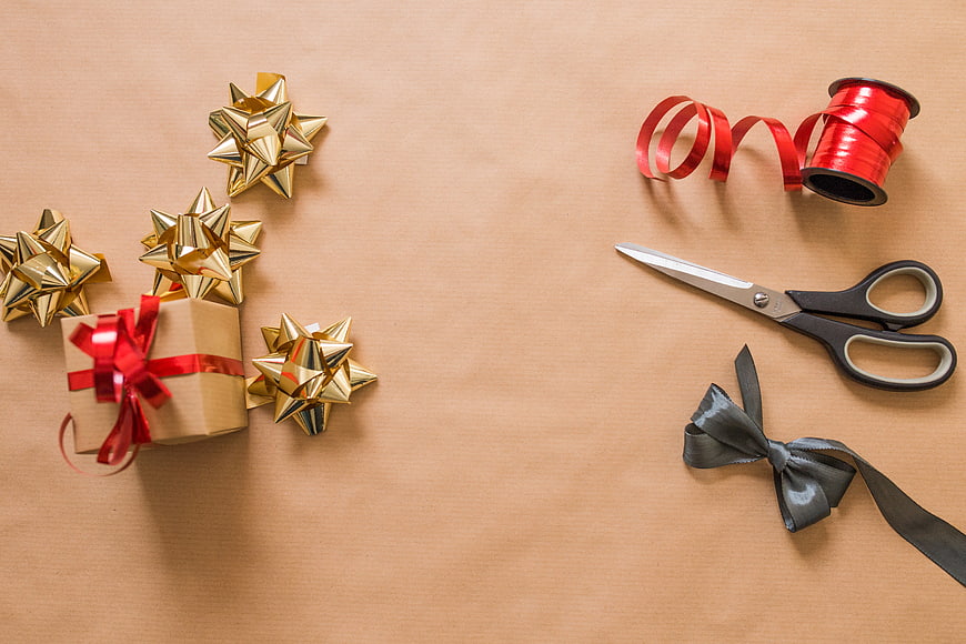 Christmas gift wrapping supplies on kraft paper background