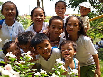 Group of happy Filipino children smiling outdoors in a garden