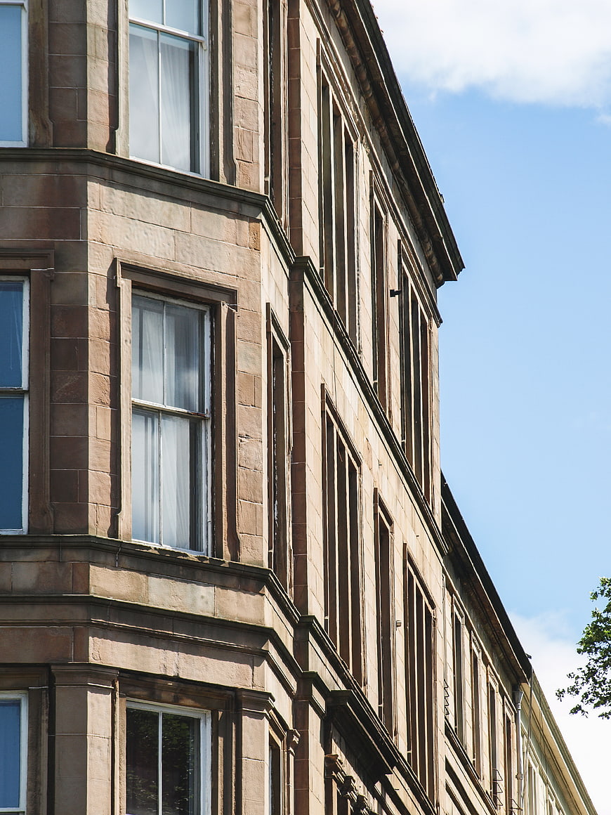 Low angle view of historic stone building facade against blue sky