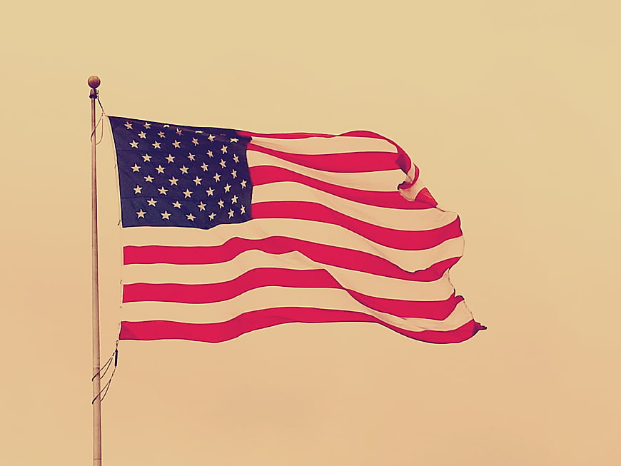 Vintage American Flag Waving Against Warm Beige Sky