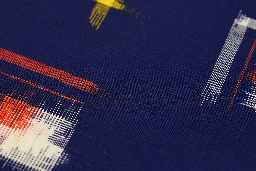 Close-up of blue woven textile with red and white geometric pattern