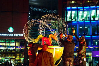 Street performers creating light painting circles at night
