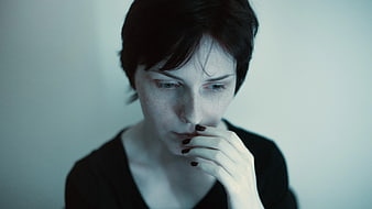 Pensive Woman with Short Hair and Dark Nail Polish