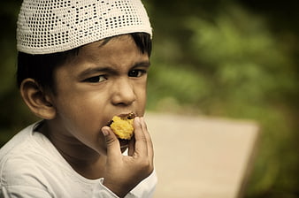 Young Muslim Boy Eating Sweet Ladoo Treat