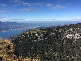Panoramic view of Lake Thun and Swiss Alps from mountain ridge