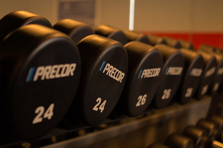 Row of black dumbbells on gym rack