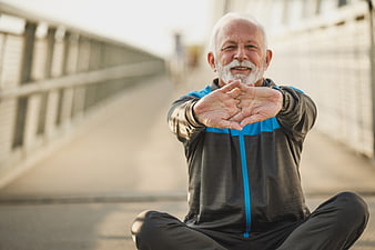Senior man stretching outdoors on a bridge