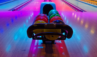 Colorful Bowling Balls in Rack on Neon Lit Lane
