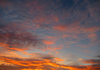 Vibrant orange and blue sunrise sky with textured clouds