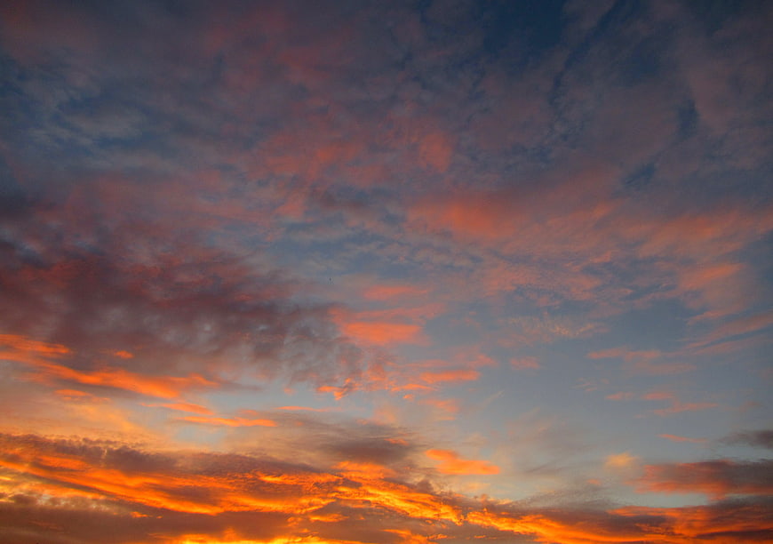 Vibrant orange and blue sunrise sky with textured clouds