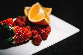 Fresh Strawberries, Raspberries, and Orange Slices on White Plate