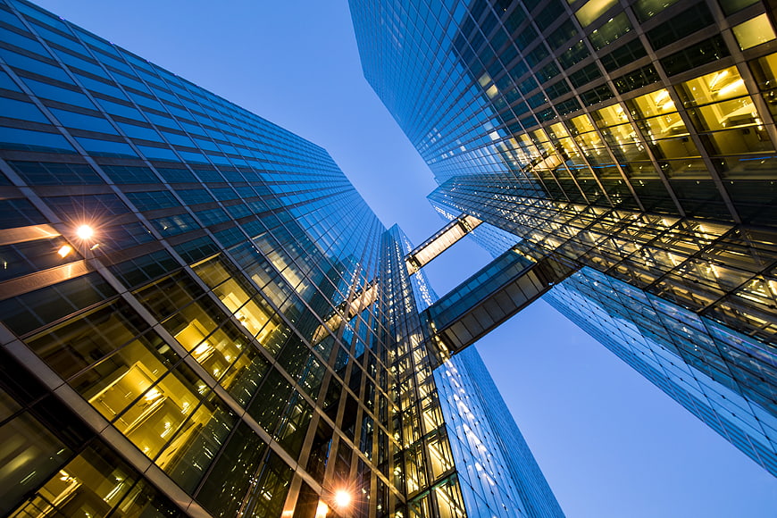 Low angle view of modern glass skyscrapers at blue hour