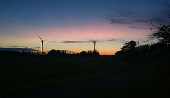 Silhouetted Wind Turbines Against a Colorful Sunset Sky