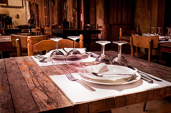 Rustic wooden table set with wine glasses and cutlery
