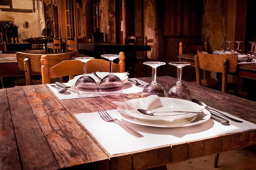 Rustic wooden table set with wine glasses and cutlery