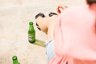 Woman relaxing with Heineken beer bottle on patio