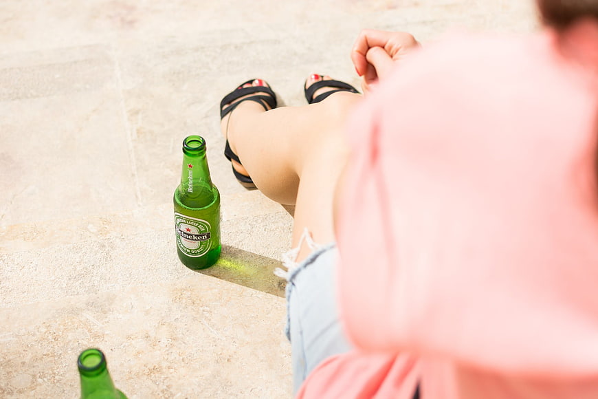 Woman relaxing with Heineken beer bottle on patio