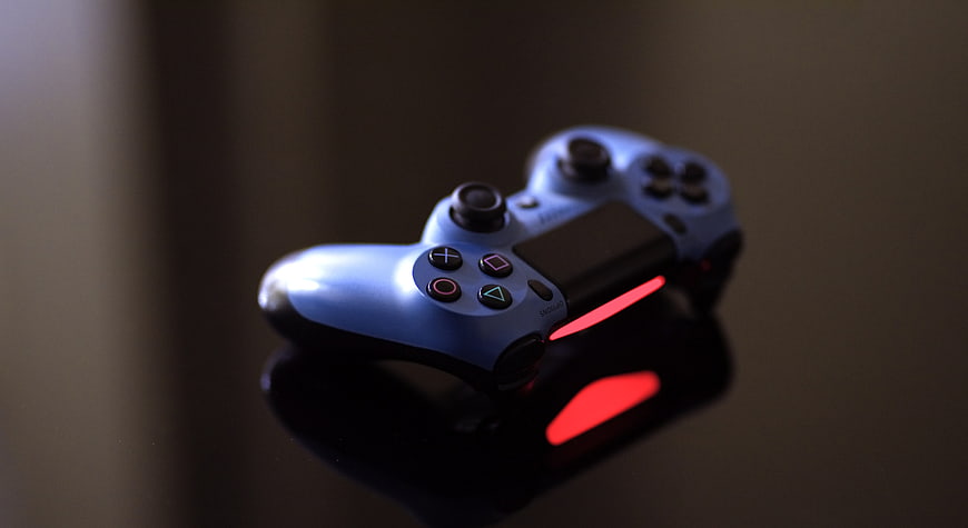 Blue PlayStation 4 Controller on Reflective Surface