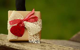 Rustic Gift Box with Red Ribbon and Heart on Wood