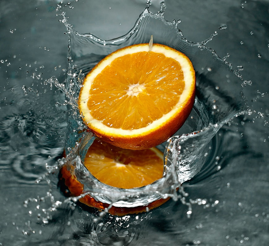 Fresh Orange Slice Splashing into Water