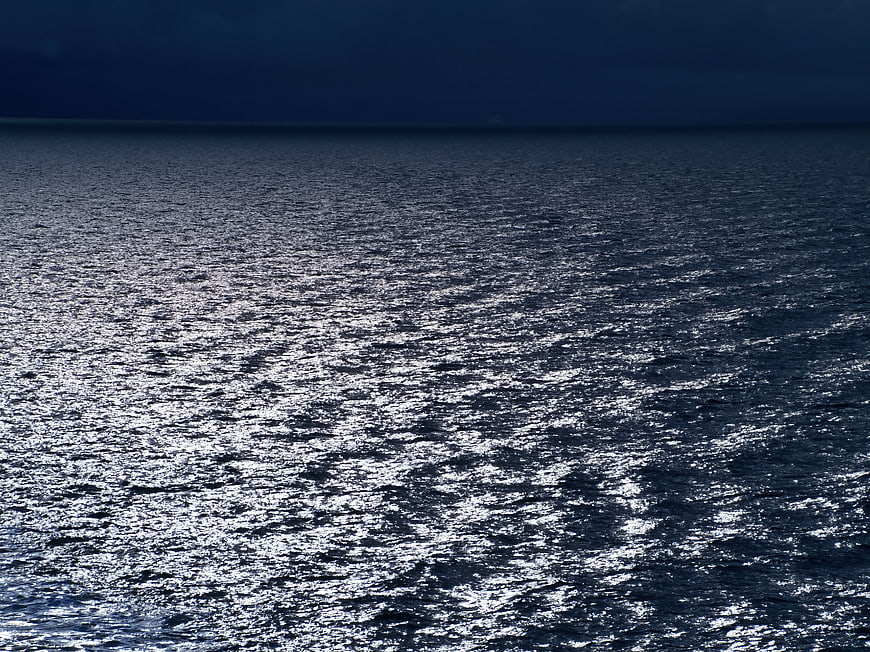 Dark Ocean Water Surface with Shimmering Sunlight Reflections