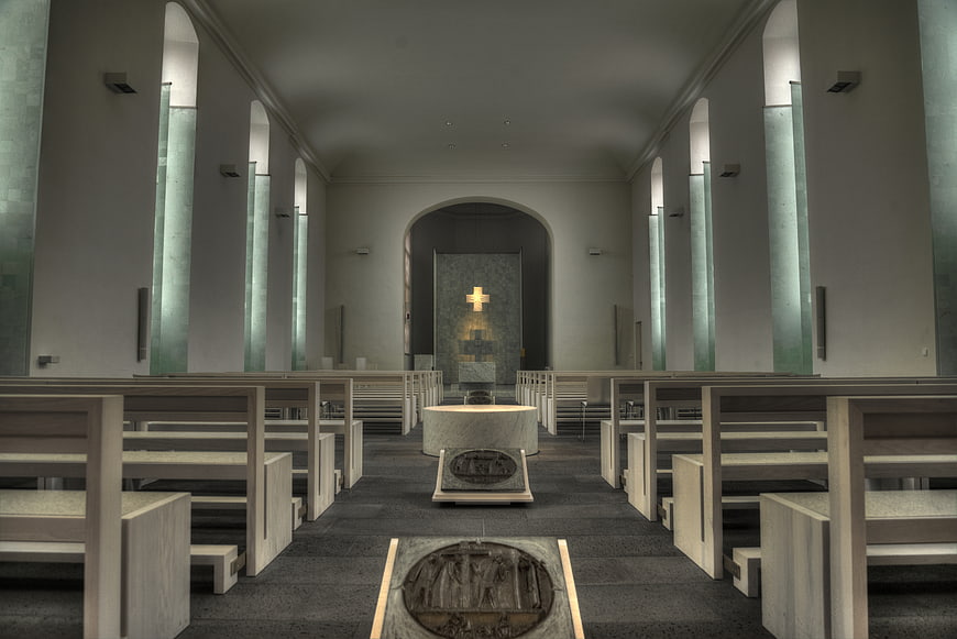 Modern Church Interior with Wooden Pews and Stone Altar