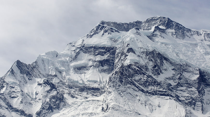 Majestic Snow-Covered Mountain Peak Under Cloudy Sky