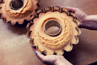 Hands Holding Freshly Baked Bundt Cake in Metal Pan