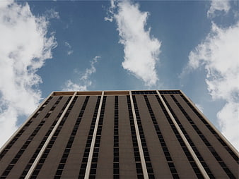 Low angle view of modern high-rise building against blue sky