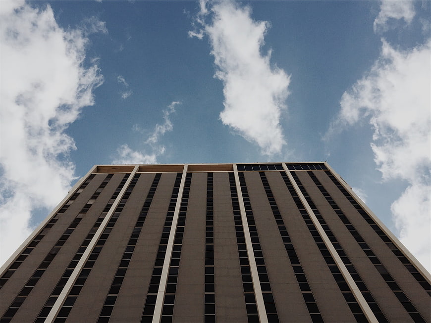Low angle view of modern high-rise building against blue sky