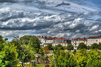 Dramatic Clouds Over European City Park and Buildings