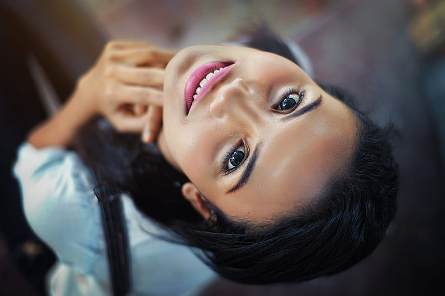 Close-up portrait of smiling woman looking up upside down