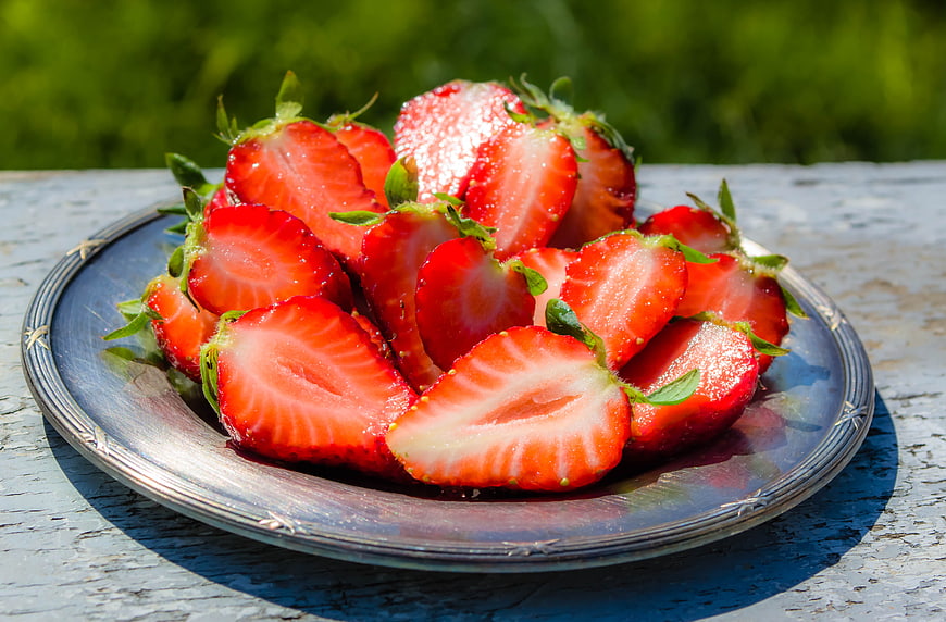 Fresh Sliced Strawberries on Silver Plate Outdoors