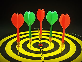 Five darts stuck in a dartboard bullseye